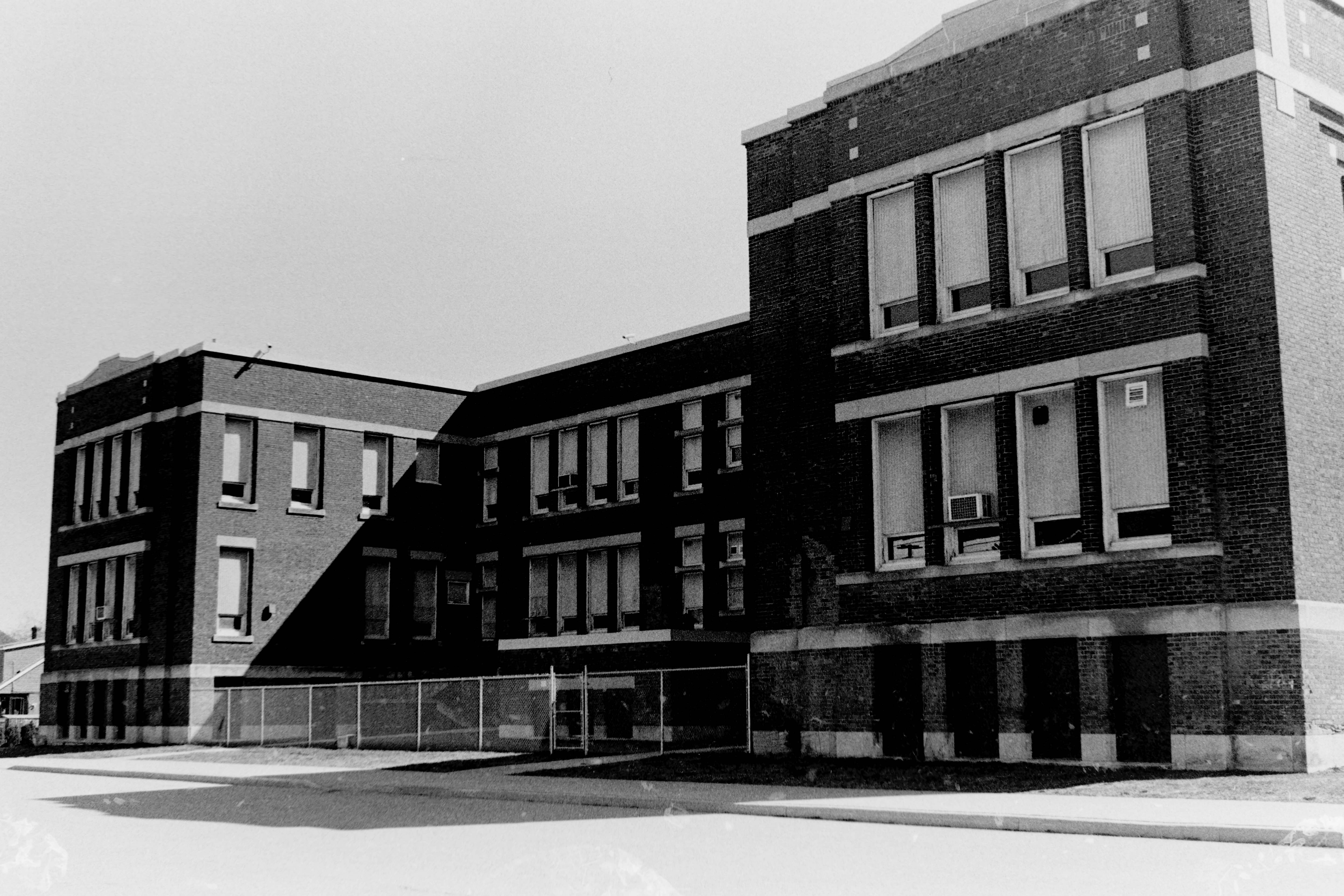 A black and white photo of a person waking in light and shadows.
